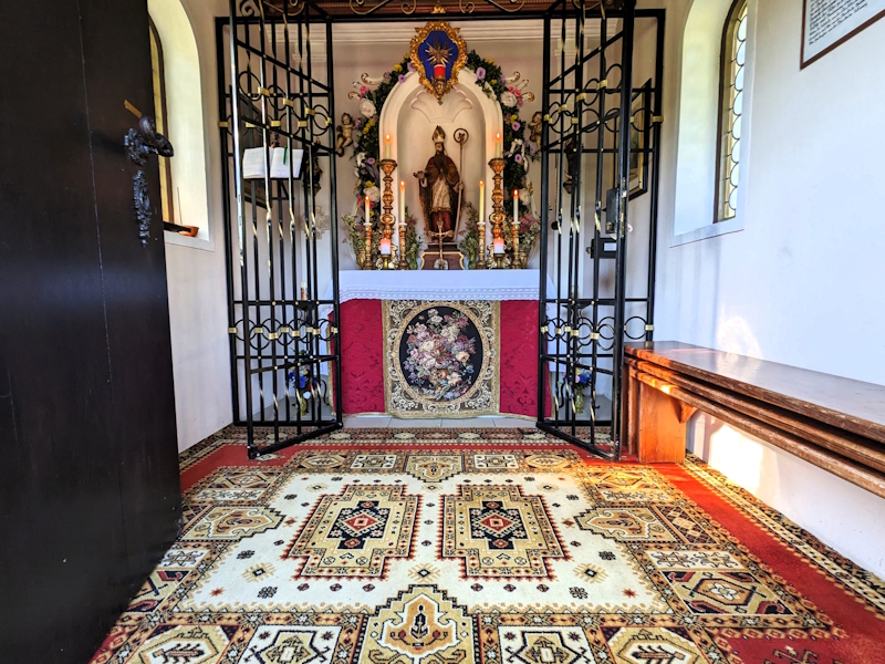 Kapelle im Festtagsschmuck mit Stifterbild und neuem Teppich.